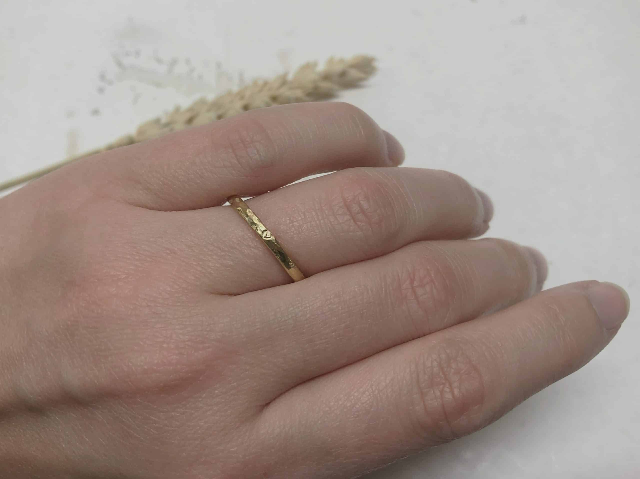 Schmaler Hammerschlagring mit Herz "Aridene" 6 Schmaler Hammerschlagring aus Gold an der Hand Modell Aridene